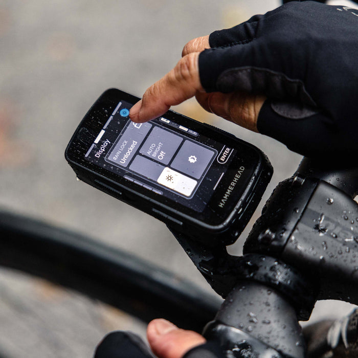 Woman clasping the Hammerhead Heart Rate Monitor on her chest before a ride